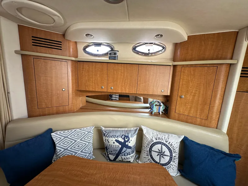 Slide: The Image of Interior of 2006 Sea Ray 320 Sundancer with wooden cabinets and decorative pillows. - 14