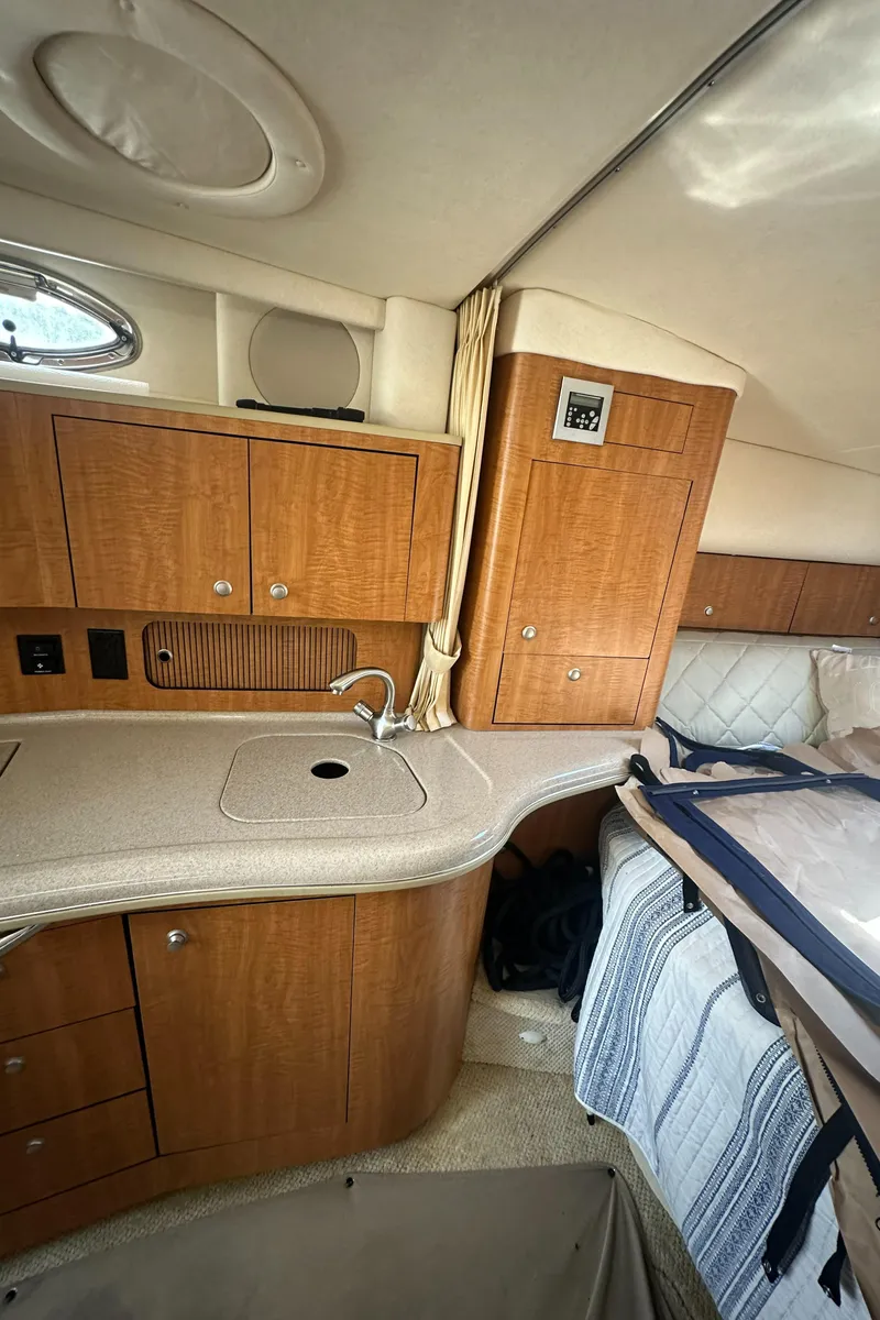 Slide: The Image of 2006 Sea Ray 320 Sundancer cabin interior with wood cabinetry and compact sink. - 17