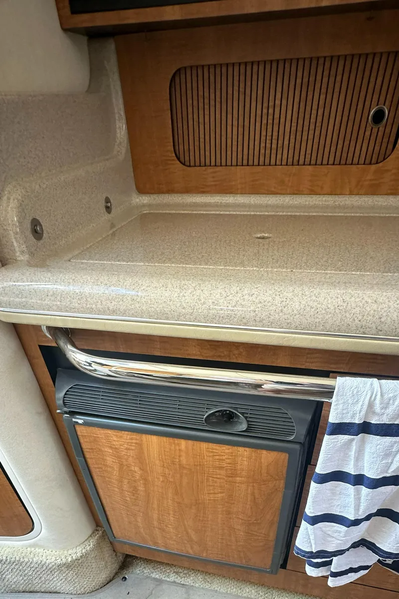 Slide: The Image of 2006 Sea Ray 320 Sundancer interior with countertop and wooden cabinetry. - 18