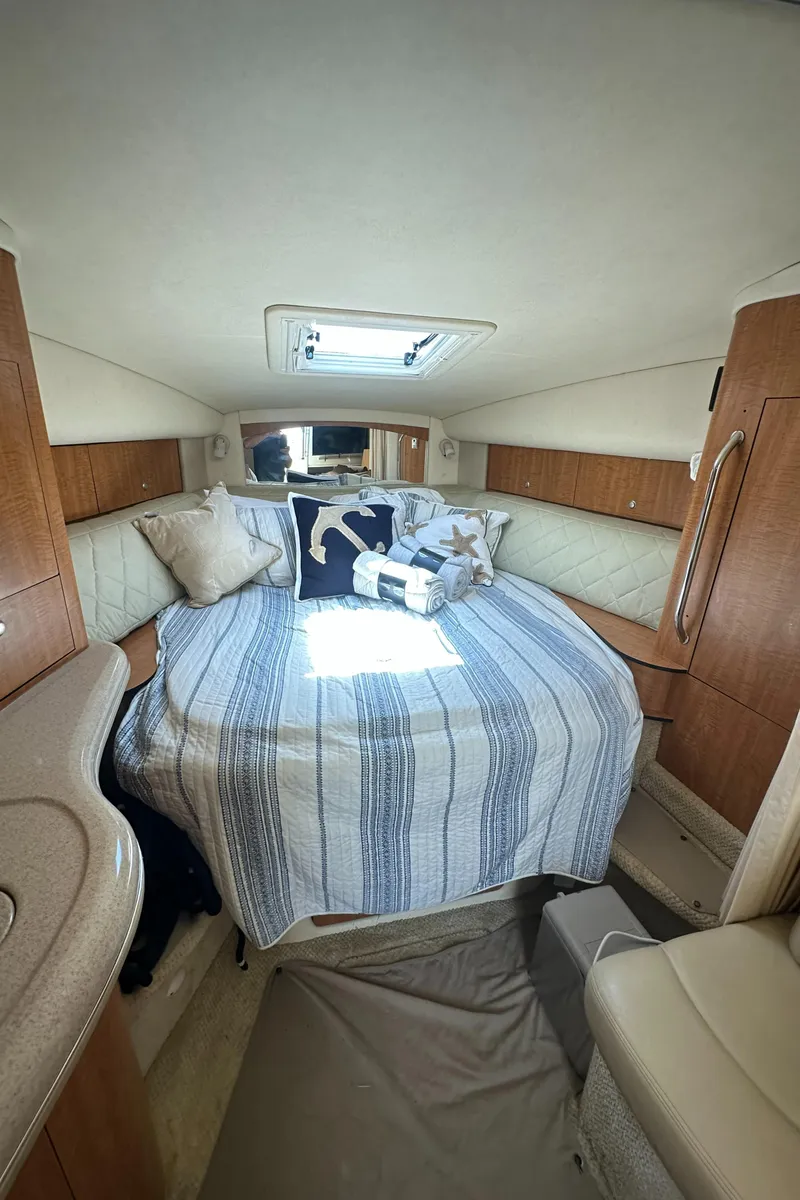 Slide: The Image of 2006 Sea Ray 320 Sundancer cabin with cozy bed and nautical decor. - 19