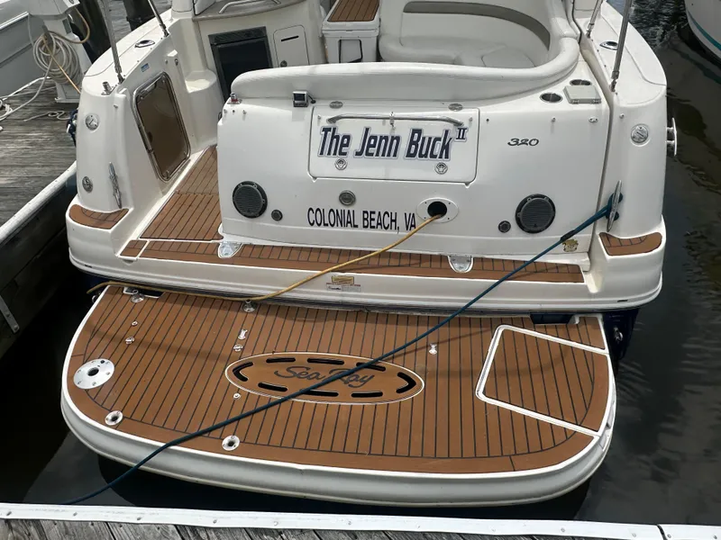 Slide: The Image of 2006 Sea Ray 320 Sundancer boat docked, featuring teak swim platform and seating area. - 2