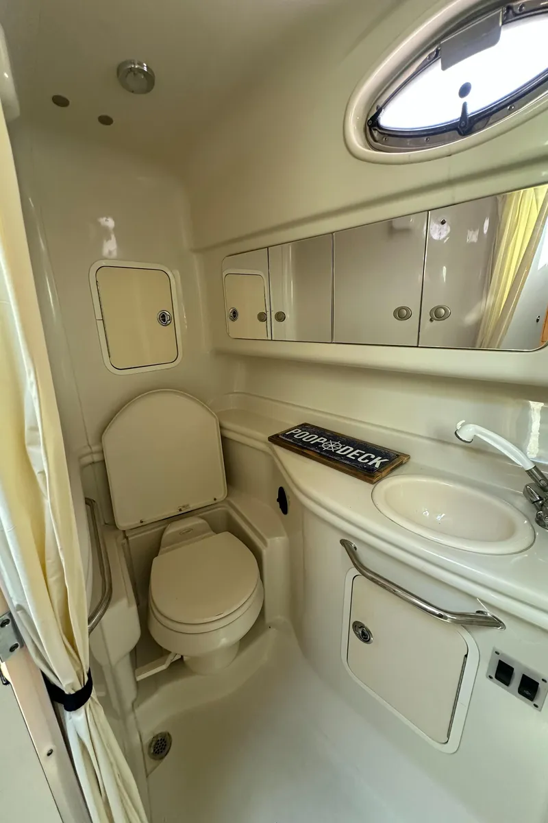 Slide: The Image of 2006 Sea Ray 320 Sundancer bathroom with sink, toilet, and storage cabinets. - 24