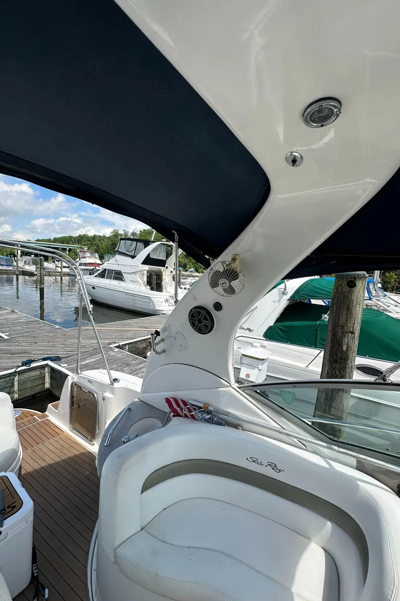 Slide: The Image of 2006 Sea Ray 320 Sundancer docked at marina, featuring sleek design and comfortable seating. - 26