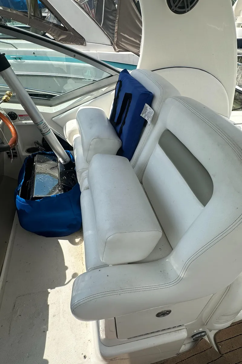 Slide: The Image of 2006 Sea Ray 320 Sundancer cockpit with white seating and blue accessories. - 5