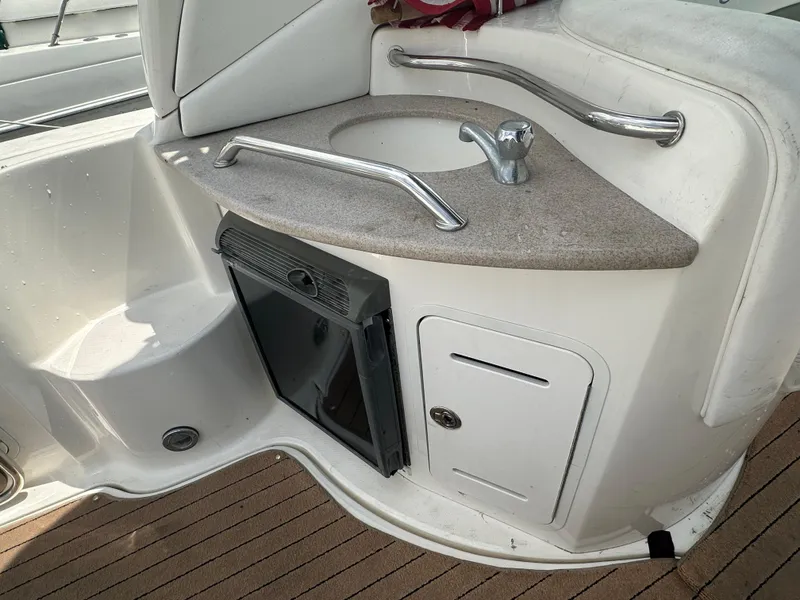 Slide: The Image of 2006 Sea Ray 320 Sundancer boat kitchenette with sink and mini fridge. - 9