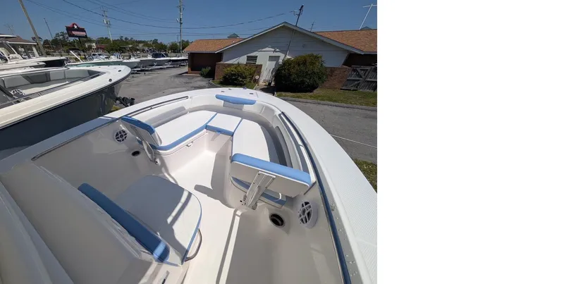 Slide: The Image of 2025 Robalo R202 Explorer boat with blue and white seating, docked outdoors. - 16