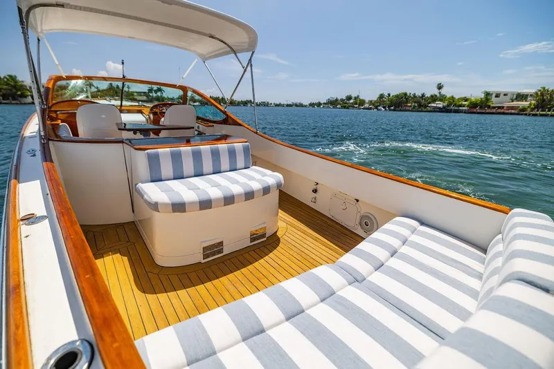 Slide: The Image of 2004 Hinckley Talaria 29 R boat with striped seating on a sunny day. - 13