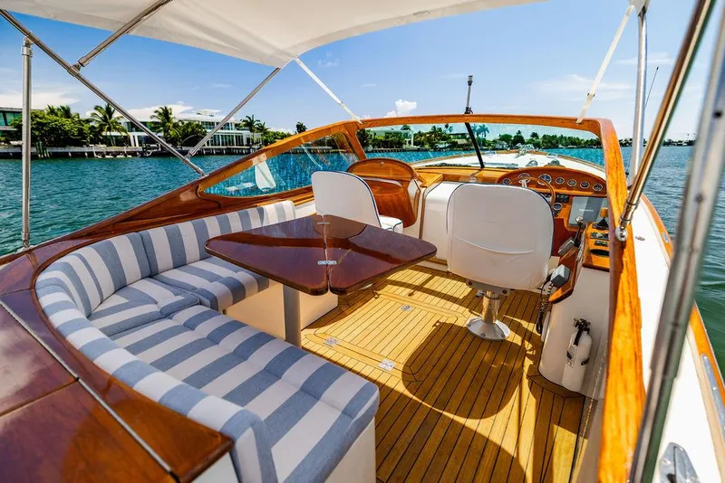 Slide: The Image of 2004 Hinckley Talaria 29 R yacht interior with striped seating and wooden accents. - 17