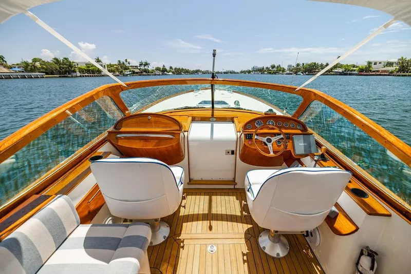 Slide: The Image of 2004 Hinckley Talaria 29 R cockpit with wooden accents and dual white seats on a sunny day. - 18