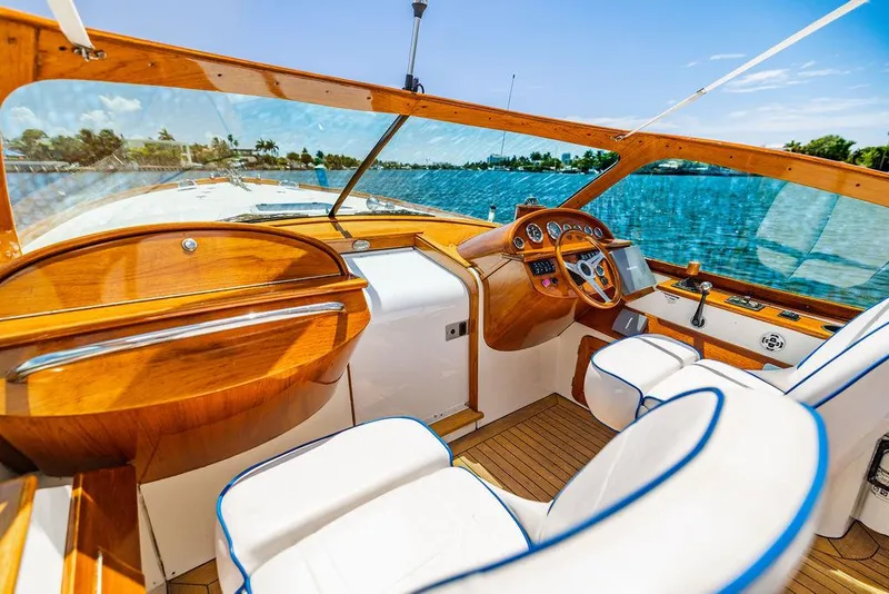 Slide: The Image of Luxurious 2004 Hinckley Talaria 29 R boat interior with wooden dashboard and white seating. - 21