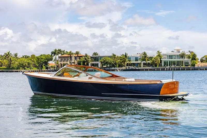Slide: The Image of 2004 Hinckley Talaria 29 R boat cruising on a sunny day near waterfront homes. - 27