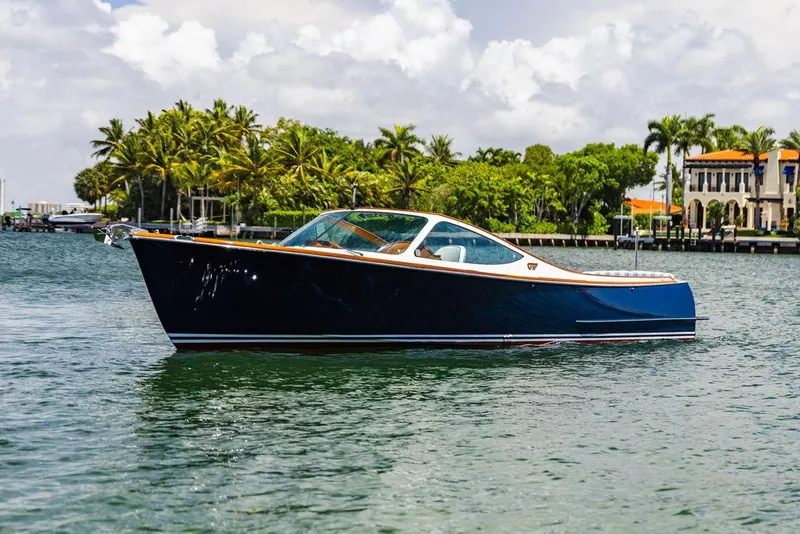 Slide: The Image of 2004 Hinckley Talaria 29 R boat on a scenic waterway with palm trees. - 30