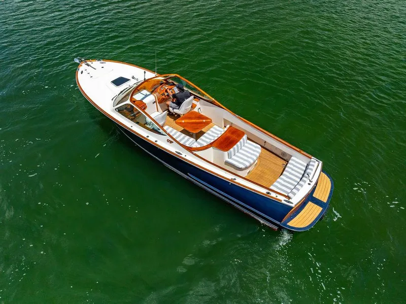 Slide: The Image of 2004 Hinckley Talaria 29 R boat on green water, featuring elegant design and wooden accents. - 31
