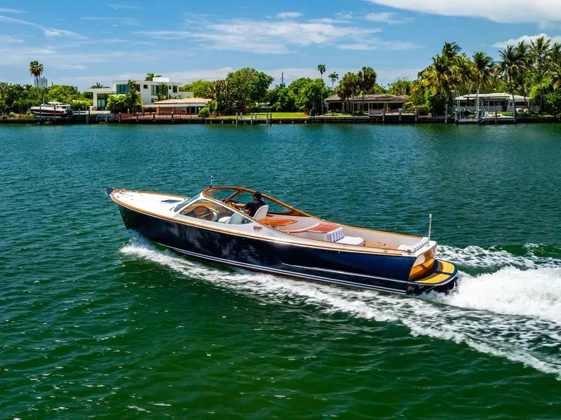 Slide: The Image of 2004 Hinckley Talaria 29 R cruising on a scenic waterway with lush greenery. - 39