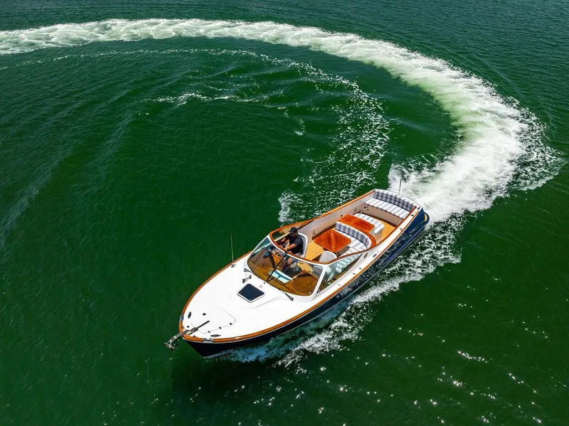 Slide: The Image of 2004 Hinckley Talaria 29 R boat making a sharp turn on open water. - 42