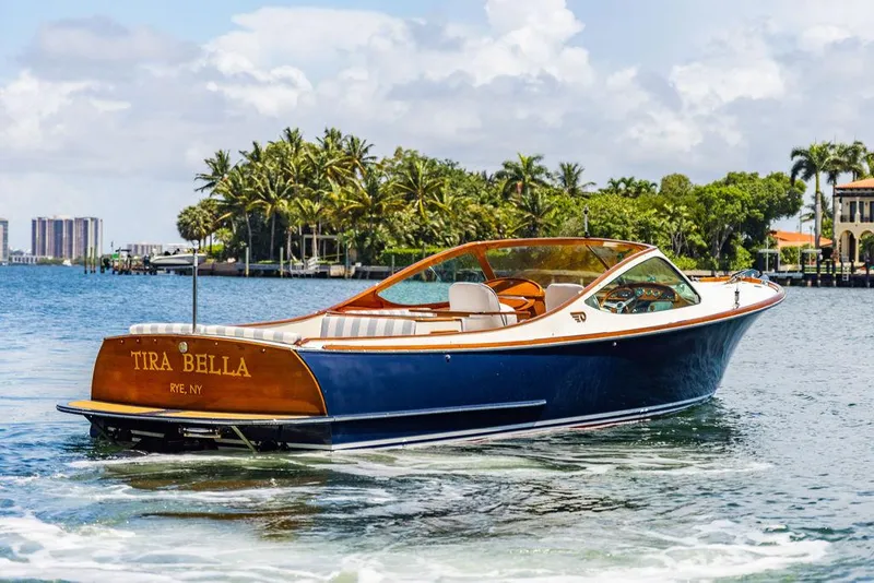 Slide: The Image of 2004 Hinckley Talaria 29 R boat cruising on a sunny day near palm trees. - 5
