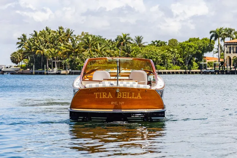 Slide: The Image of 2004 Hinckley Talaria 29 R boat on water, palm trees in background. - 6