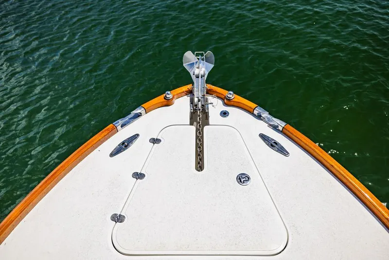 Slide: The Image of Bow of 2004 Hinckley Talaria 29 R boat on water, featuring anchor and teak trim. - 8