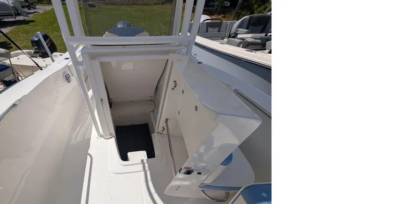 Slide: The Image of 2025 Robalo R202 Explorer boat interior storage compartment, open hatch, white finish. - 13