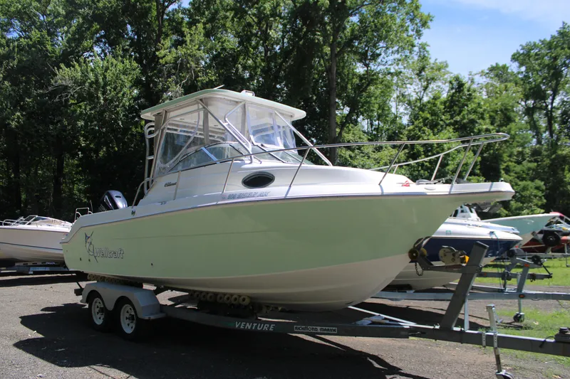 Slide: The Image of 2001 Wellcraft 230 Coastal boat on trailer in wooded area. - 1