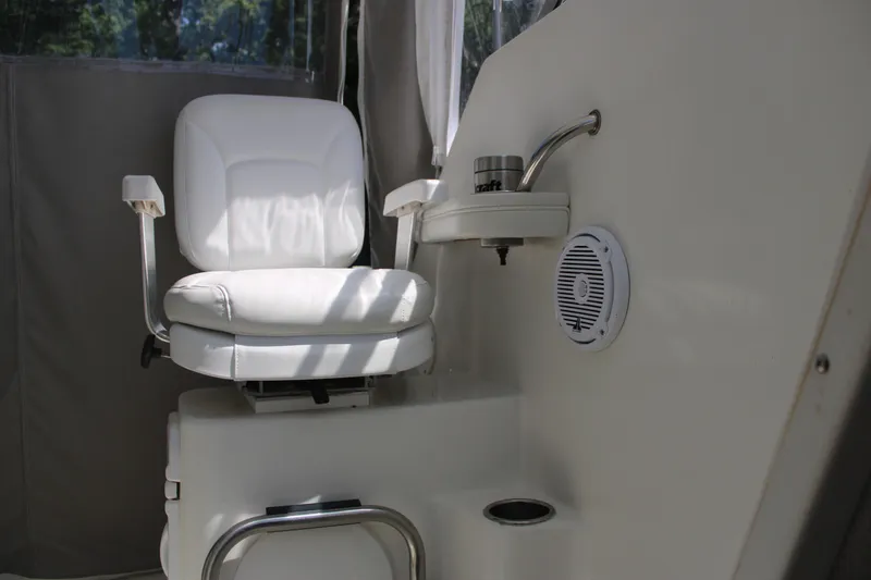 Slide: The Image of White captain's chair on 2001 Wellcraft 230 Coastal boat, featuring a speaker and cup holder. - 10