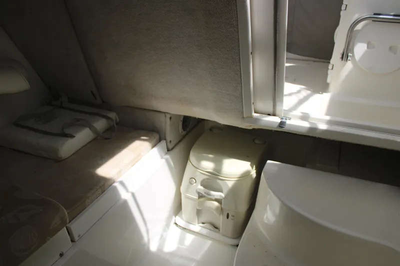 Slide: The Image of 2001 Wellcraft 230 Coastal cabin interior with portable toilet and seating area. - 16