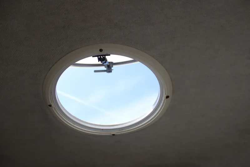 Slide: The Image of Circular hatch on 2001 Wellcraft 230 Coastal boat, open to blue sky. - 18