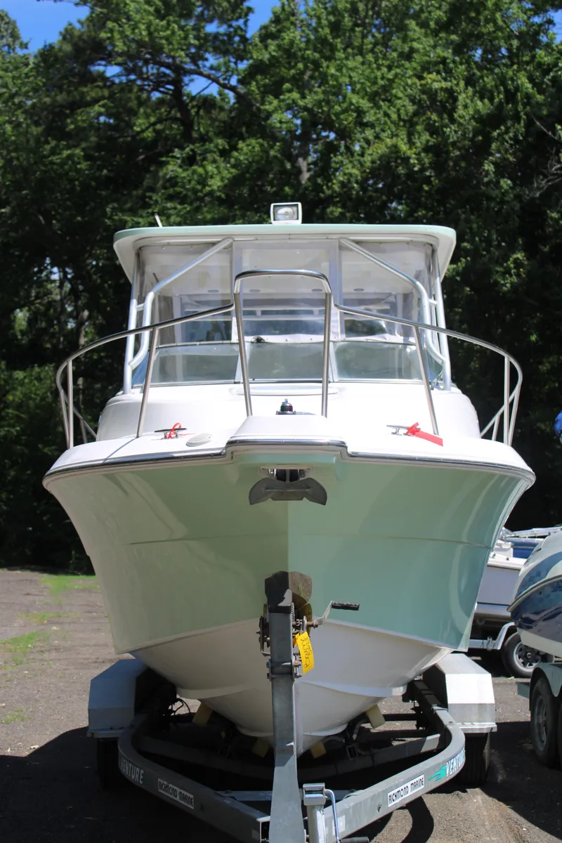 Slide: The Image of 2001 Wellcraft 230 Coastal boat on trailer, surrounded by trees. - 2