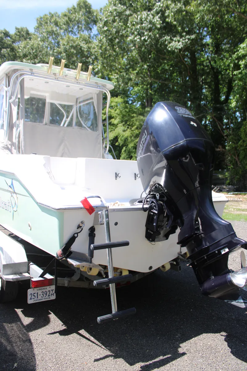 Slide: The Image of 2001 Wellcraft 230 Coastal boat with outboard motor, parked on a sunny day. - 4