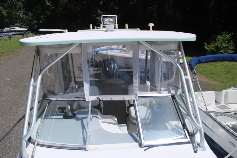 Slide: The Image of 2001 Wellcraft 230 Coastal boat with enclosed cockpit and windshield, docked outdoors. - 5