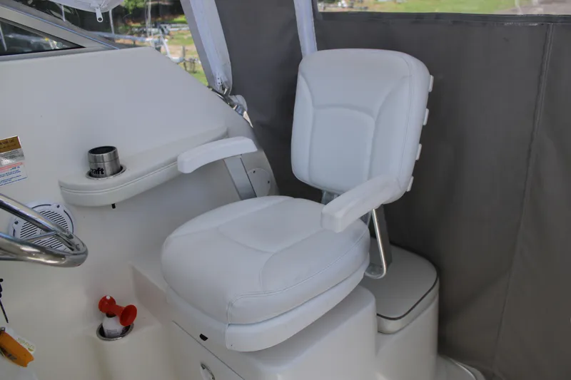 Slide: The Image of Captain's chair on 2001 Wellcraft 230 Coastal boat, featuring white upholstery and armrests. - 9
