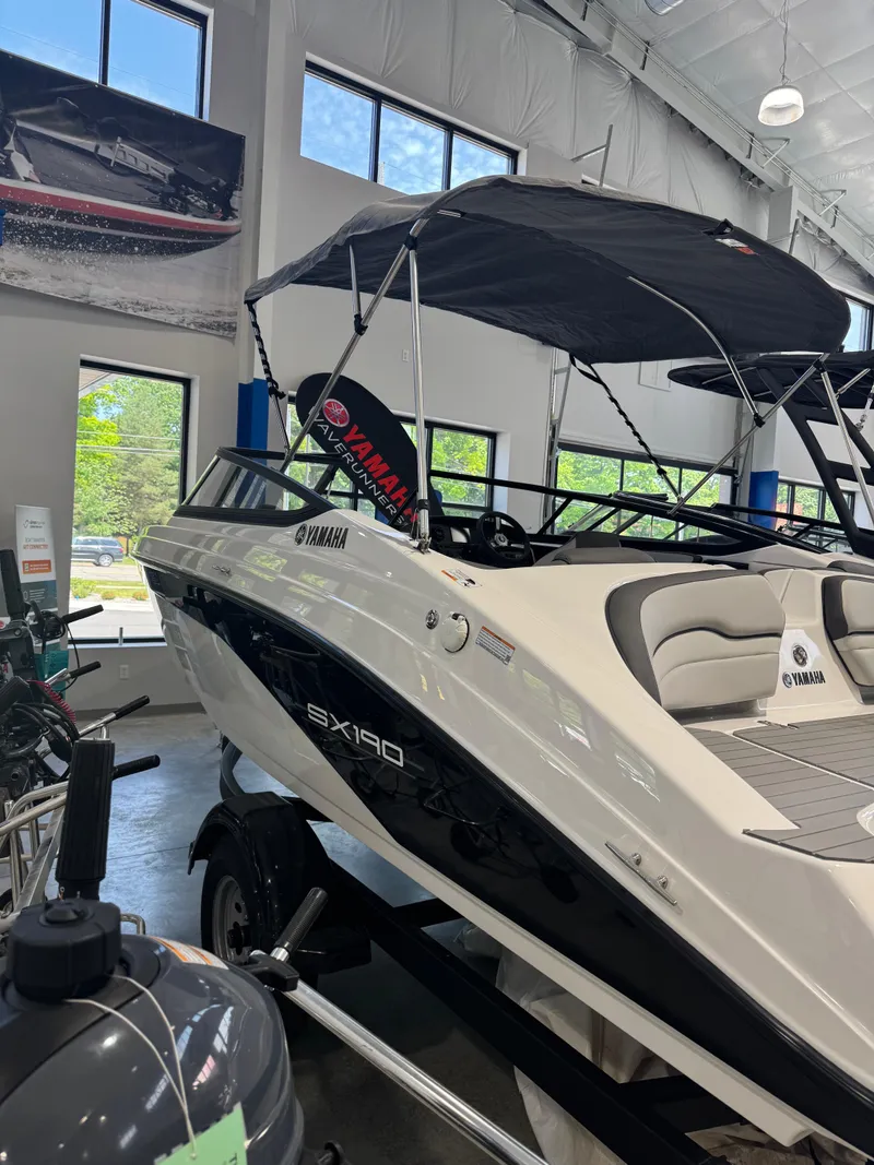The Image of 2025 Yamaha Boats SX190 in showroom, featuring sleek design and modern canopy. - 0