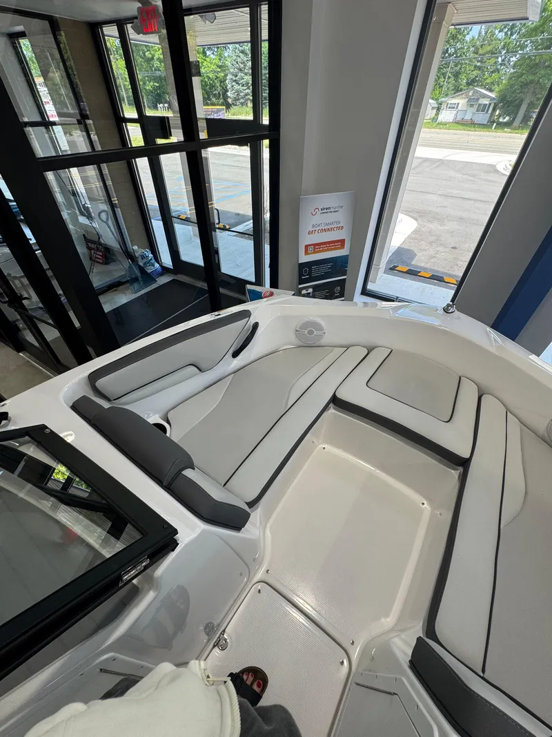 Slide: The Image of 2025 Yamaha Boats SX190 interior with sleek seating and modern design in showroom. - 12
