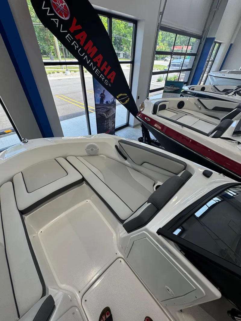 Slide: The Image of 2025 Yamaha Boats SX190 interior, showcasing sleek seating and modern design in a showroom. - 13
