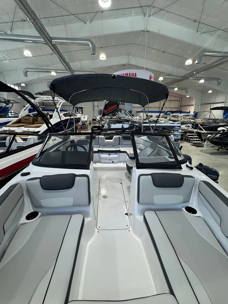 Slide: The Image of 2025 Yamaha Boats SX190 in showroom, featuring sleek design and spacious seating. - 14