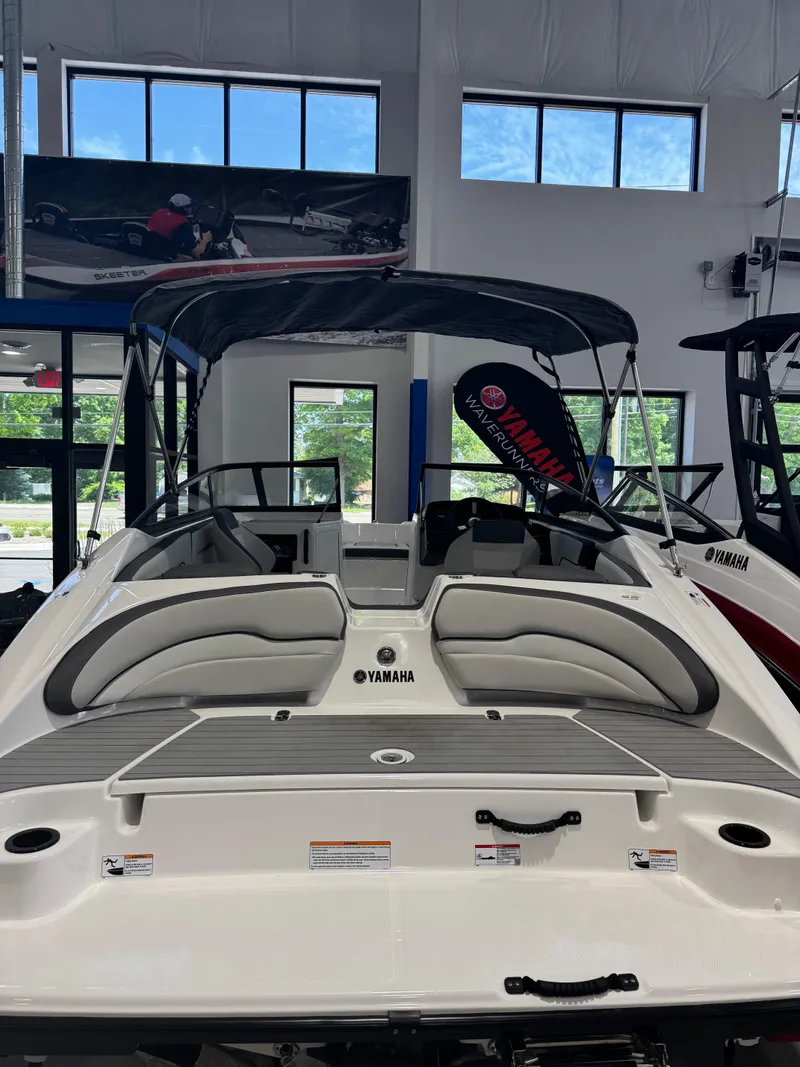 Slide: The Image of 2025 Yamaha Boats SX190 in showroom, featuring sleek design and comfortable seating. - 2