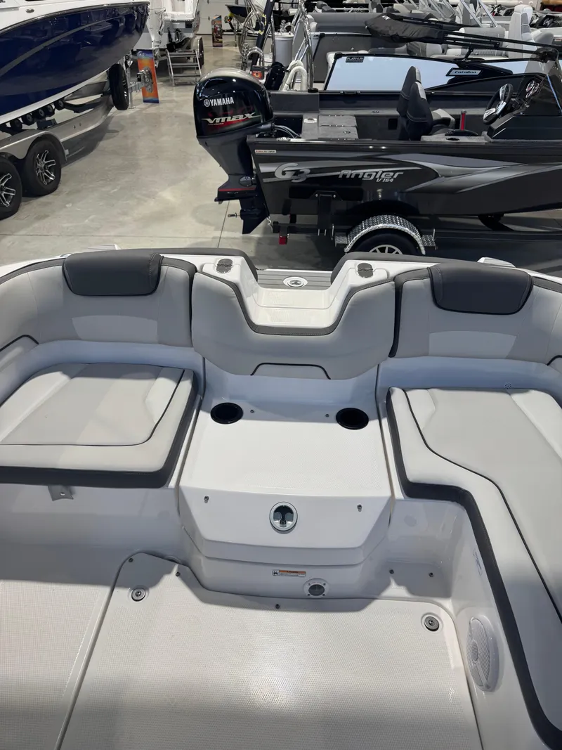Slide: The Image of 2025 Yamaha Boats SX190 interior with seating and cup holders in a showroom. - 6