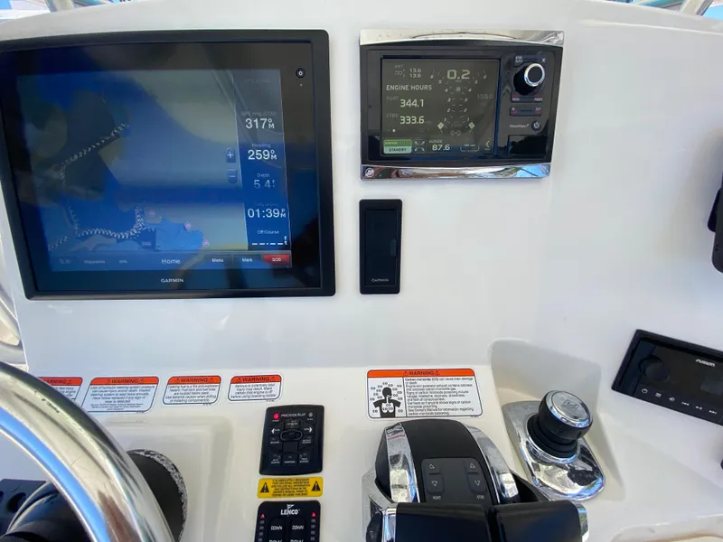 Slide: The Image of Control panel of a 2014 Mako 284 CC boat with navigation displays. - 16