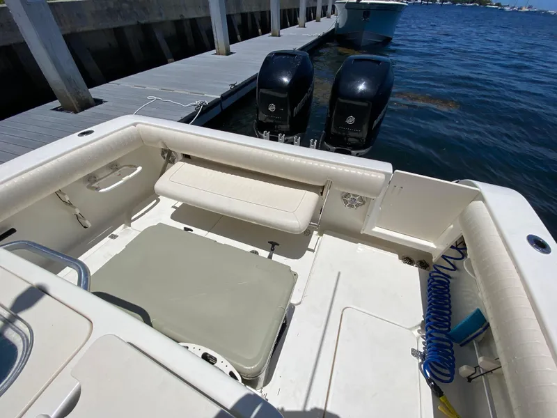 Slide: The Image of 2014 Mako 284 CC boat interior with dual engines at dock. - 18