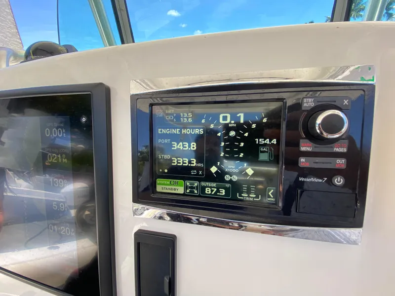 Slide: The Image of Dashboard of a 2014 Mako 284 CC boat displaying engine hours and navigation data. - 21