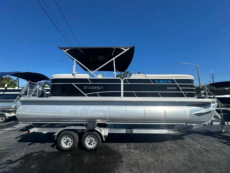 The Image of 2022 Godfrey Sweetwater 2286 FS pontoon boat on trailer under clear blue sky. - 0