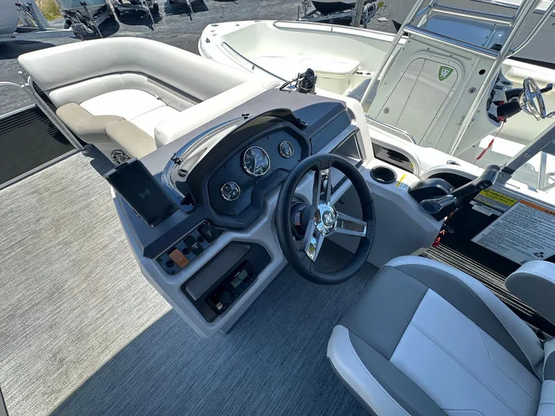 Slide: The Image of 2022 Godfrey Sweetwater 2286 FS boat interior with steering wheel and seating area. - 13