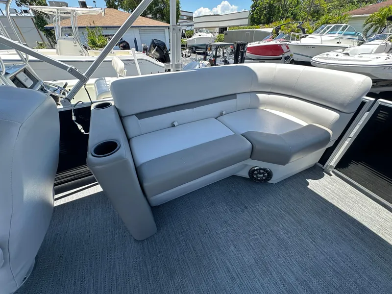 Slide: The Image of 2022 Godfrey Sweetwater 2286 FS boat interior with gray seating and cup holders. - 16