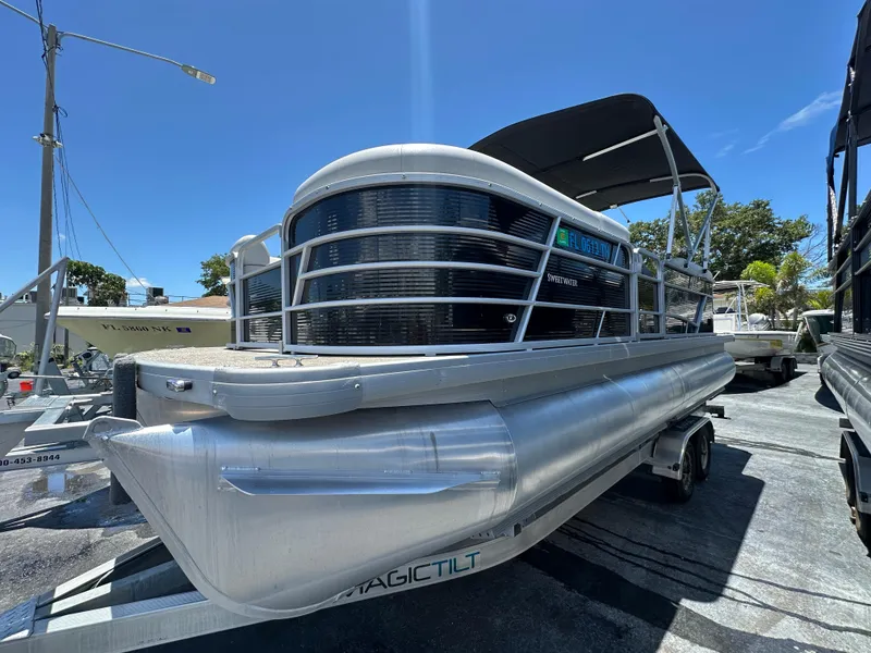 Slide: The Image of 2022 Godfrey Sweetwater 2286 FS pontoon boat on trailer, sunny day. - 2