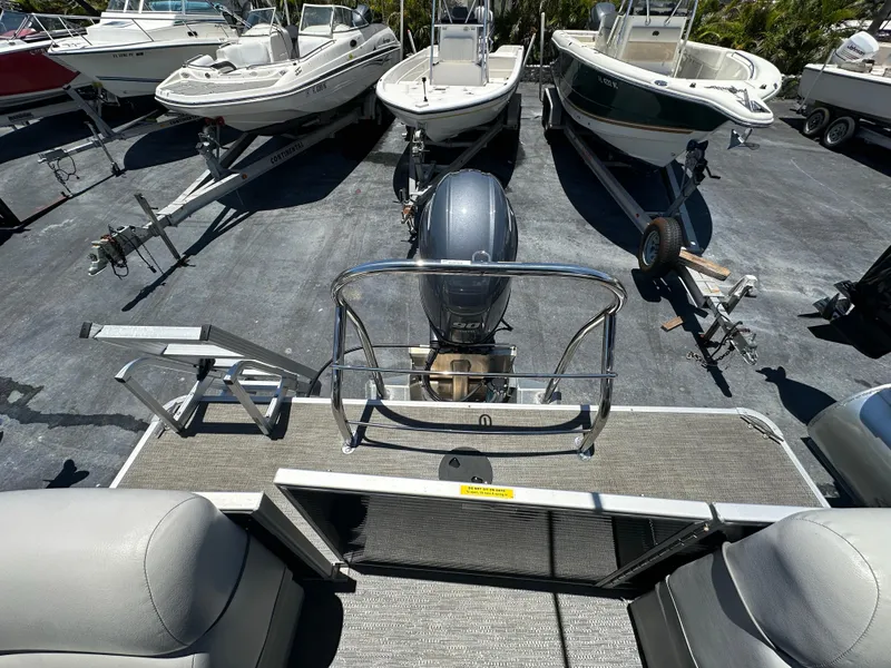 Slide: The Image of 2022 Godfrey Sweetwater 2286 FS pontoon boat with motor, docked among other boats. - 7