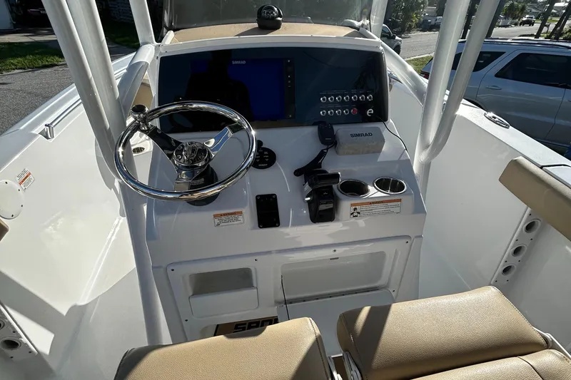 Slide: The Image of 2017 Sportsman Heritage 231 Center Console boat dashboard with steering wheel and navigation controls. - 20