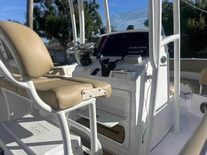 Slide: The Image of 2017 Sportsman Heritage 231 Center Console boat interior with beige seating and modern controls. - 3
