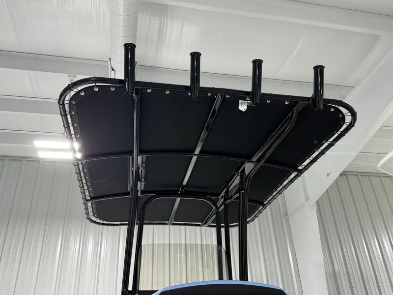 Slide: The Image of 2025 Robalo R202 Explorer T-top with rod holders in a showroom. - 16