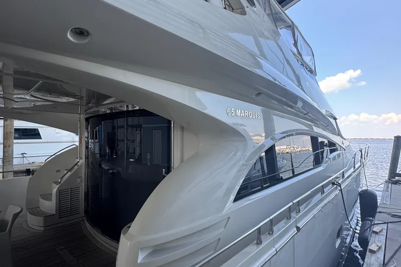 Slide: The Image of Luxury 2006 Marquis 65 yacht docked, showcasing sleek design and spacious deck. - 10