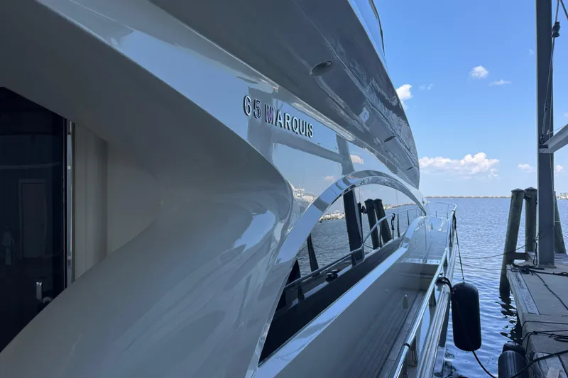 Slide: The Image of Luxury 2006 Marquis 65 yacht docked by the water on a sunny day. - 11
